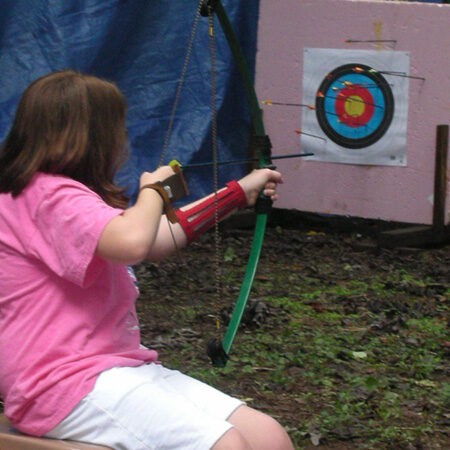 Mary C. aiming at a target at an archery session